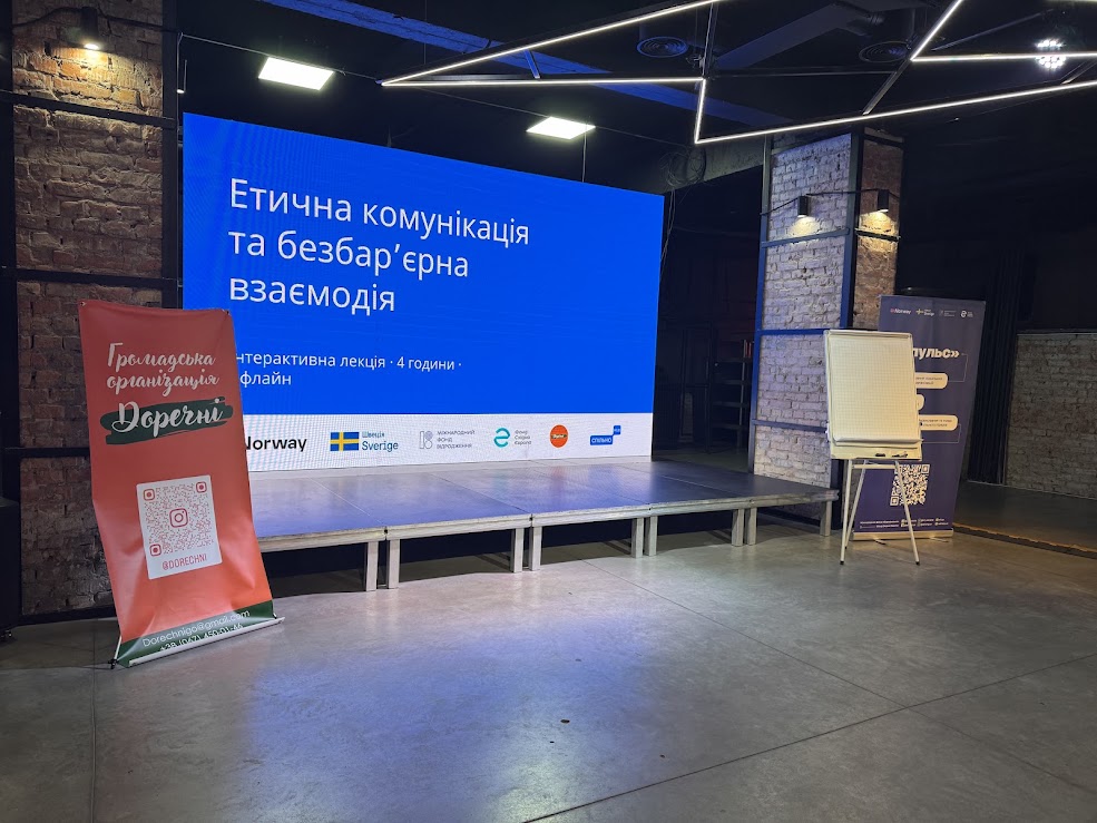 Фото з місця подій, місцевого "Незламного Хабу". Світлина зроблена до початку заходу. На екрані зображена тема лекції. Також поруч розміщені банери - ГО "Доречні" та грантодавців проєкту "Імпульс".